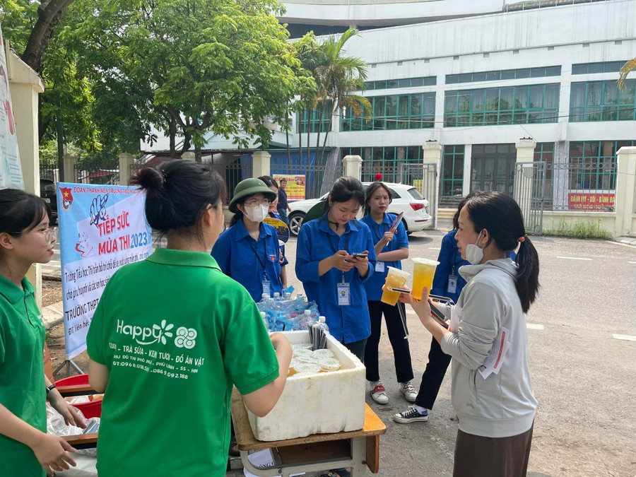 Tình nguyện viên phát trà xanh miễn phí cho thí sinh tại điểm thi.