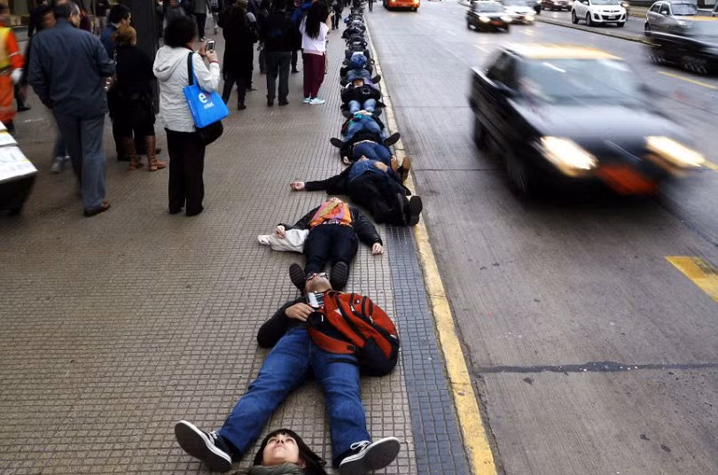 Demonstrators lie on the ground to represent people who disappeared and went missing during Augusto Pinochet