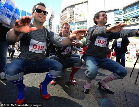 Một nhóm các thanh niên trẻ thể hiện khả năng giữ thăng bằng và vận động khi đi giày cao gót.