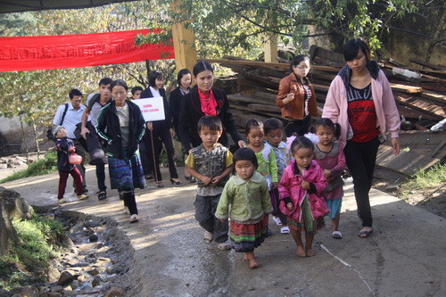 Cô giáo và phụ huynh học sinh Trường tiểu học Bản Khoang đưa học trò đến trường