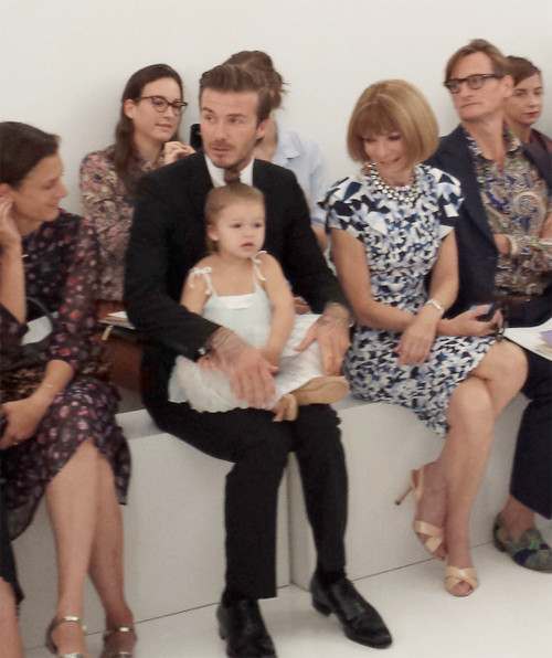 Harper ngồi gọn trong lòng bố khi cả hai bố con tới ủng hộ mẹ Vic ra mắt bộ sưu tập mới tại Tuần lễ thời trang New York tuần trước. Bà Anna Wintour, với mái tóc bob kinh điển và mặc váy họa tiết ngồi bên cạnh Becks, mỉm cười nhìn Harper. Ảnh: Huff.