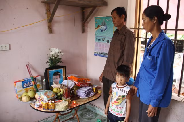 Ông bà nội cùng anh trai trước di ảnh của cháu Hà Gia Bách. Ảnh: gdtd.vn