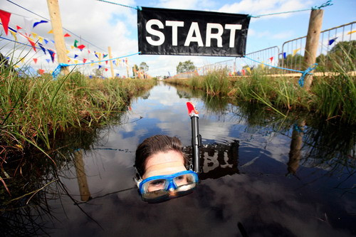 A competitor crosses the Start/Finish line during the Northern Ireland Bog Snorkeling Championships in Peatlands Park, Dungannon, County Tyrone July 26, 2009. (REUTERS/Cathal McNaughton)