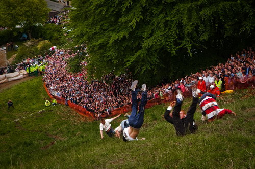 A scene from the annual Cooper’s Hill Cheese-Rolling and Wake was held near Gloucester, England. After this notoriously dangerous race for the cheese, the man upside down was taken away to the hospital. (© Will De Freitas) 