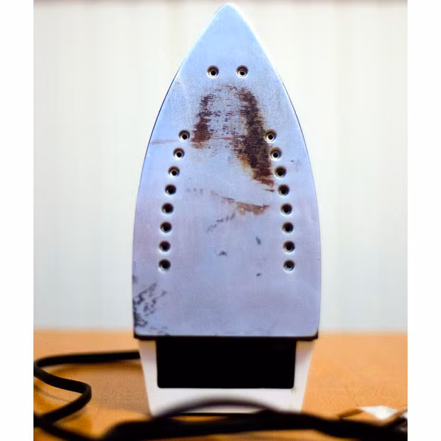 Residue in the shape of an image of Jesus Christ is seen on the bottom of an electric iron at the home of Mary Jo Coady, in Methuen, Massachusetts. Coady says the image has reassured her that 