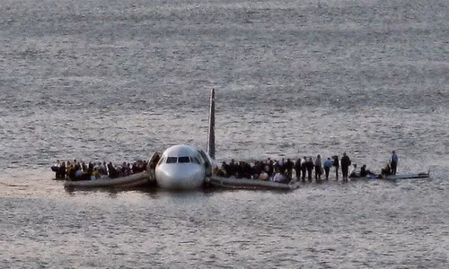 Airline passengers wait to be rescued on the wings of a US Airways Airbus 320 jetliner that safely ditched in the frigid waters of the Hudson River in New York, after a flock of birds knocked out both its engines on January 15, 2009. (AP Photo/Steven Day, File)