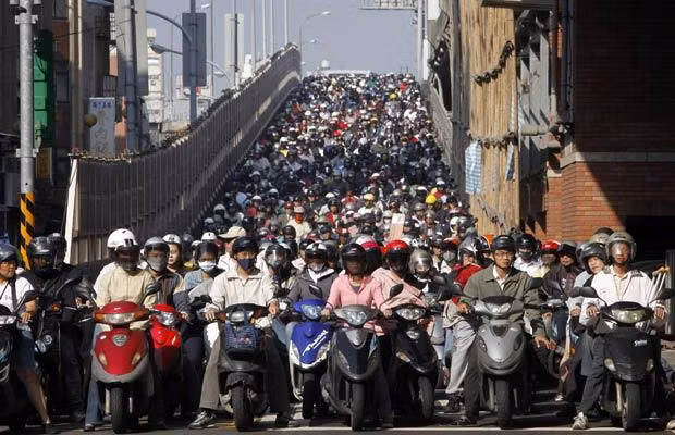 Motorists crowd at a junction during rush hour in Taipei October 29, 2009. There are around 8.8 million motorcycles and 4.8 million cars on Taiwan’s roads and nearly all motor vehicles and inhabitants are squeezed into a third of the island’s area