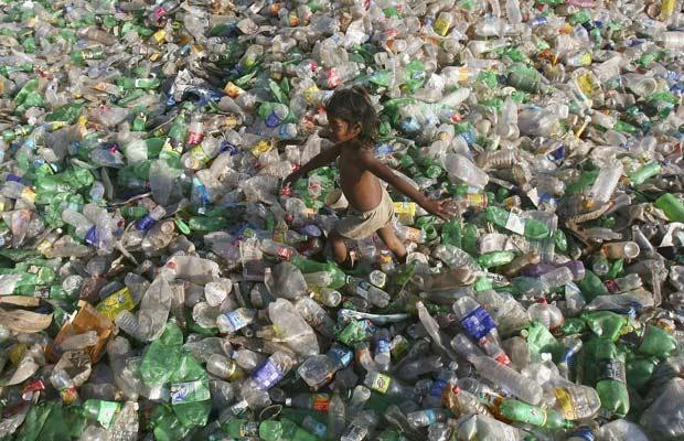 Sức "ăn mòn" kinh hoàng của biến đổi khí hậu ảnh 12 A child walks through a junkyard of waste plastic bottles at Dhanas village on the outskirts of the northern Indian city of Chandigarh November 21, 2009