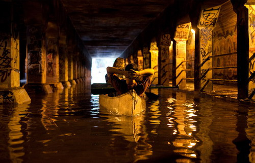 A local couple canoes through Atlanta’s famous Krog Tunnel on September 21st, 2009, after flooding followed heavy rains throughout the region. (© Caroline Smith)