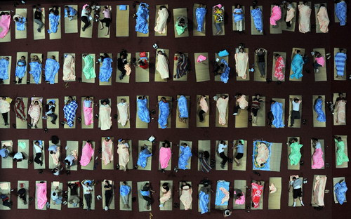 Chinese parents gather to sleep at an auditorium after they accompanied their children to a university to start their first semester in Wuhan, central China’s Hubei province on September 7, 2009. (STR/AFP/Getty Images)