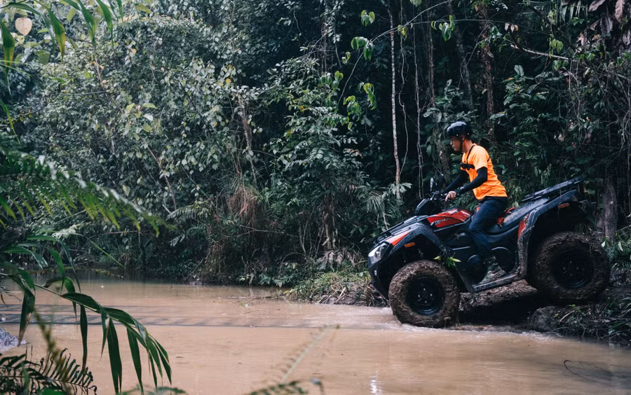 Khách tham quan điều khiển xe băng qua khe suối.