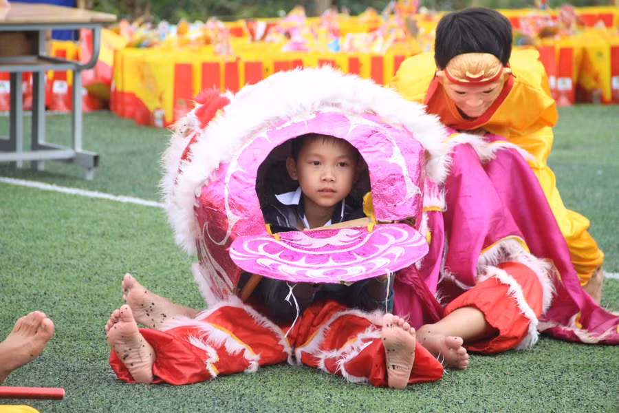 Những em nhỏ "biến hoá" thành đội lân vui nhộn.