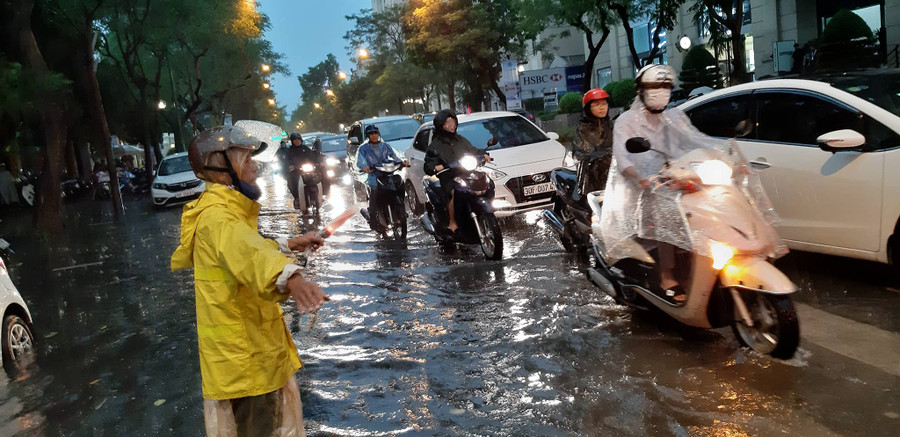 Công nhân xí nghiệp thoát nước số 1 đã ra điểm ngập để chỉ dẫn cho các phương tiện tránh những điểm ngập sâu