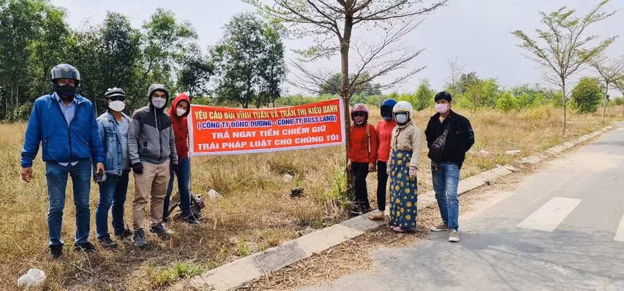 Khách hàng căng băng rôn yêu cầu ông Bùi Vĩnh Tuấn trả lại tiền.