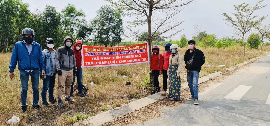 Khách hàng căng băng rôn yêu cầu ông Bùi Vĩnh Tuấn trả lại tiền.