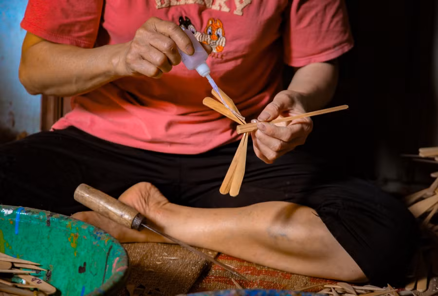 Sau khi chuồn chuồn được cân bằng, người nghệ nhân mới tiến hành tra keo để cố định các mối ghép trên thân và cánh chuồn chuồn.