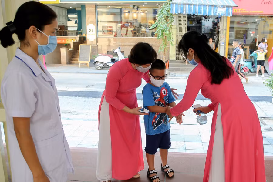 Tất cả các em trước khi vào trường đều được đo thân nhiệt, rửa tay bằng dung dịch khử khuẩn.