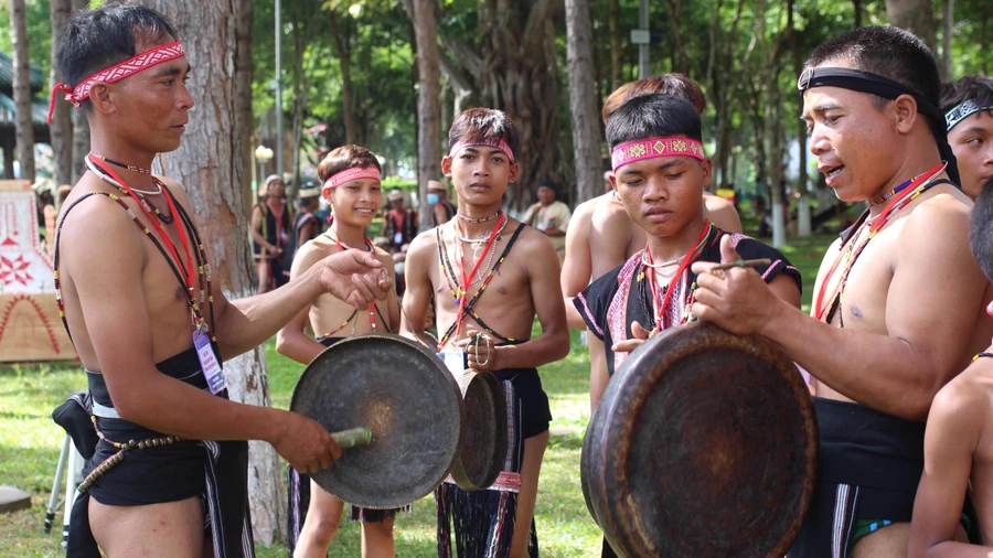 Anh Đinh A Lênh (bên trái) hướng dẫn các em nhỏ đánh chiêng.