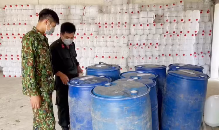 Cơ quan chức năng tiến hành kiểm tra các thùng phuy bên trong kho hàng. Ảnh: Công an An Giang.