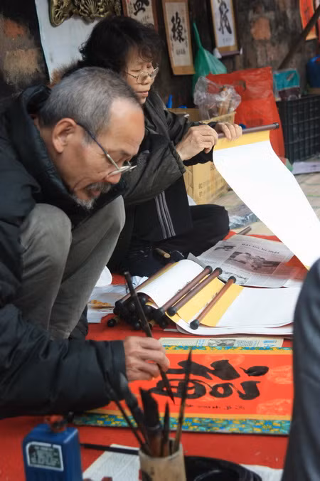 Hai vợ chồng nhà thư pháp đang say mê sáng tác. Ảnh, gdtd.vn