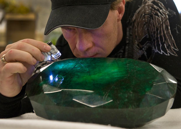 Những hình ảnh ấn tượng trong tuần ảnh 7 Regan Reaney, owner of the the world’s largest emerald, looks over the gem at the Western Star Auction House in Kelowna, British Columbia, Canada. The 57,500 carat emerald, named