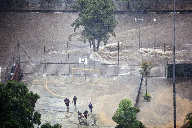 Những hình ảnh ấn tượng trong tuần ảnh 4 Boys play football in the midst of heavy rain that flooded a street in Sao Paulo, Brazil