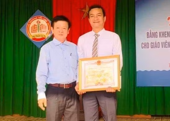 Phó Giám đốc Sở GD&amp;ĐT Quảng Trị - ông Phan Hữu Huyện trao Bằng khen của Chủ tịch UBND tỉnh tuyên dương thầy giáo Bùi Văn Quý.