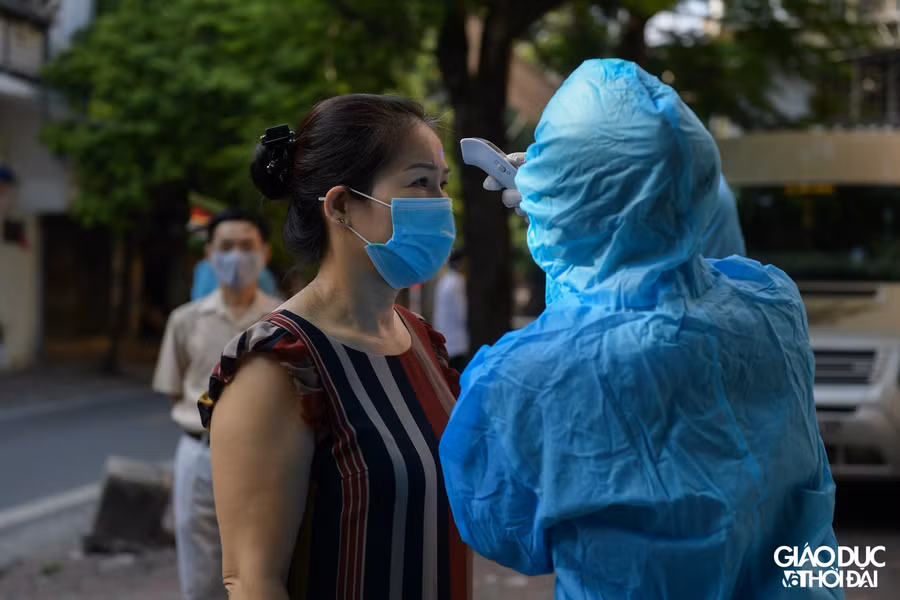 Tất cả người dân đến test đều phải đo nhiệt độ và rửa tay sát khuẩn trước khi vào bên trong.