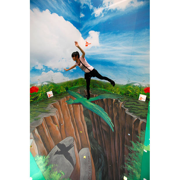 A girl poses on a 3D chalk drawing in an exhibition entitled 