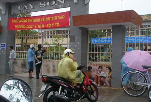 Người nhà TS đội mưa trước các HĐT ở Đà Nẵng chờ TS kết thúc buổi thi thứ 3 của đợt thi CĐ