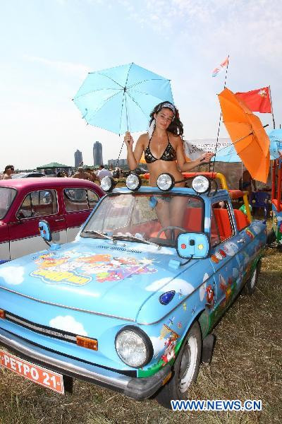 A model stands in a vehicle during the Exhibition of Autoexotica 2010 at the Tushino airport in the suburbs of Moscow, Russia, July 10, 2010.
