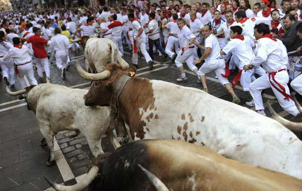 Nín thở vì… bò tót ảnh 4 Runners take the Estafeta corner next to Penajara fighting bulls during the first running of the bulls on the second day of the San Fermin festival in Pamplona July 7, 2010. There were no serious injuries in the run that lasted two minutes and twenty three seconds, according to the Navarra government press office.