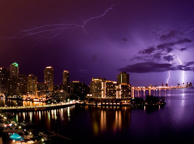 Lightning illuminates the night sky and strikes two buildings over South Beach, Miami 