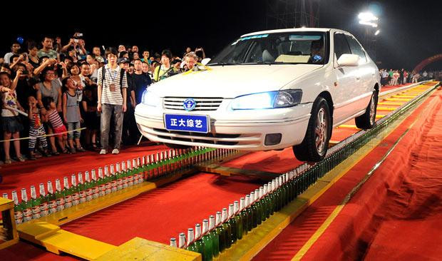 A driver sets a new Guinness World Record by driving along two rows of beer bottles for 60 metres. Li Guiwen, an army driver from Beijing, set the record at a record-setting event hosted by China Central Television and the Guinness World Record Office. He drove along two beer ’roads’ composed of 1,798 bottles that had been set up in Wenzhou, eastern China’s Zhejiang province. Li drove along the two standing tracks for 60.19 metres in a time of 8m 28s. He had previously attempted the same stunt last year but failed after wet weather caused his right tyre to slip