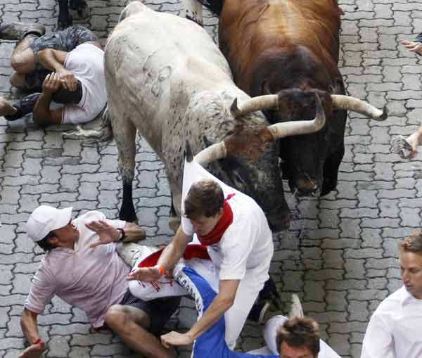 Nín thở vì… bò tót ảnh 5 A Penajara fighting bull grabs a runner by the shirt on the first day of the running of the bulls during the San Fermin festival in Pamplona