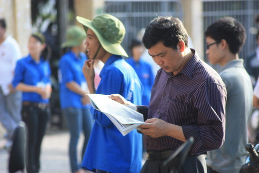 Đọc báo trong khi đợi thí sinh làm bài thi. Ảnh, gdtd.vn