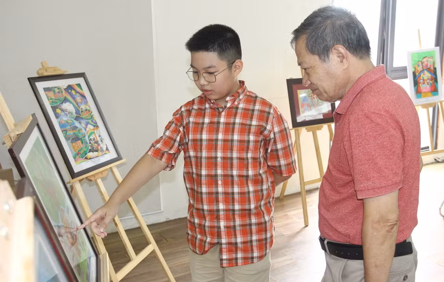 Học sinh và phụ huynh xem những bức tranh do các em vẽ.