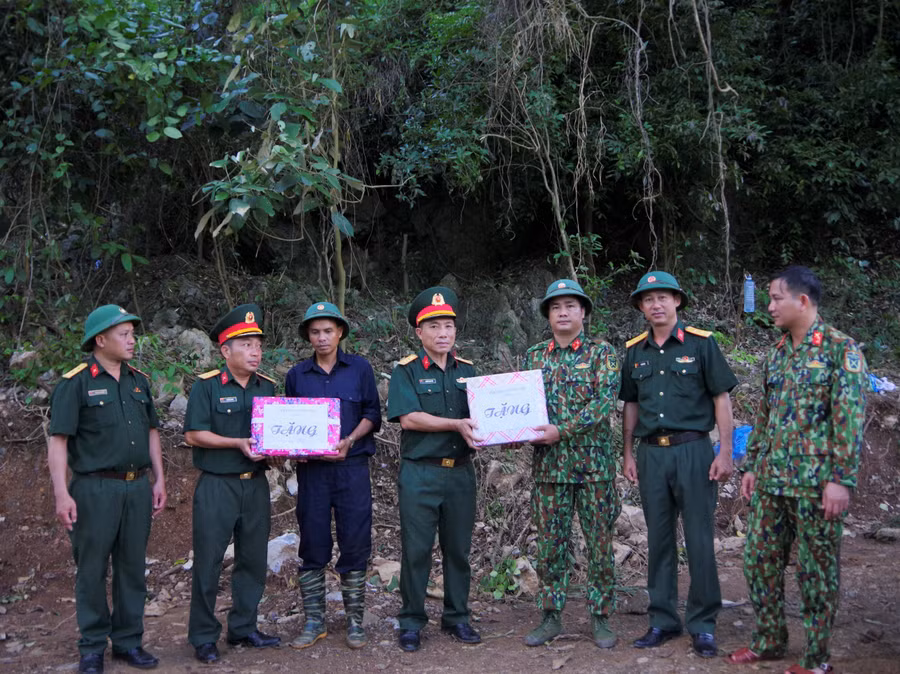 Tặng quà, động viên các thành viên trong đội tìm kiếm hài cốt liệt sĩ. (Ảnh: Duy Đông)