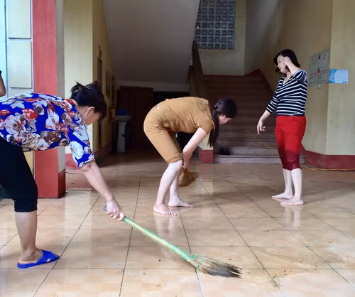 Các giáo viên Trường tiểu học Nam Phương Tiến A vệ sinh lớp học ngay sau khi nước rút