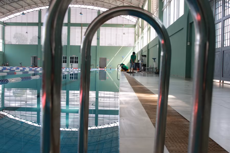 Nhân viên kỹ thuật kiểm tra điều kiện vận hành tại bể bơi của Trường Đại học Tây Nguyên. (Ảnh: Bảo Hưng).