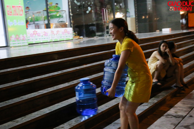 Một số người mang những bình 40l để đựng nước.