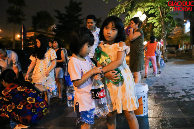 Nhiều bạn nhỏ thì cầm những chai nhựa 2l xuống lấy nước.
