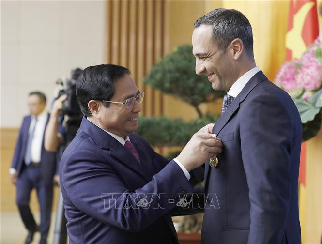Thủ tướng Phạm Minh Chính trao Huân chương Hữu nghị của Chủ tịch nước cho ông John Paul Pullicino Said Anthony, nguyên Tổng giám đốc Công ty TNHH Pfizer Việt Nam. Ảnh: Dương Giang/TTXVN.