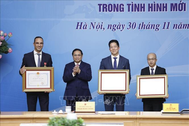 Thủ tướng Phạm Minh Chính trao Huân chương Hữu nghị của Chủ tịch nước cho ông John Paul Pullicino Said Anthony, nguyên Tổng giám đốc Công ty TNHH Pfizer Việt Nam và Bằng khen của Thủ tướng cho cá nhân ông Darrell Oh, Tổng giám đốc Công ty TNHH Pfizer Việt Nam và tập thể Công ty TNHH AstraZeneca Việt Nam. Ảnh: Dương Giang/TTXVN.