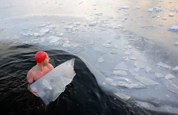 Những hình ảnh ấn tượng trong tuần ảnh 7 Julian Guy breaks the ice to make more room for other winter swimmers in the Serpentine in Hyde Park, London