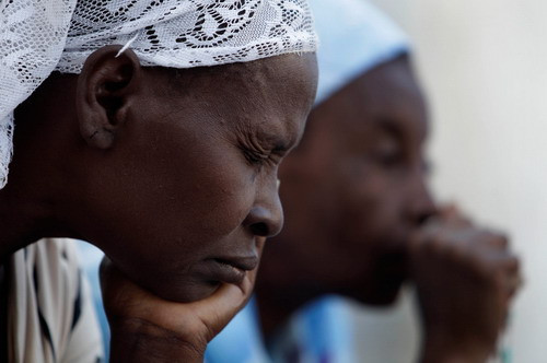 Women pray during Mass held outside the city’s main Cathedral in Port-au-Prince, Sunday, Jan. 17, 2010. About one hundred people celebrated Mass Sunday morning just outside the Cathedral, which was totally destroyed in Tuesday’s earthquake