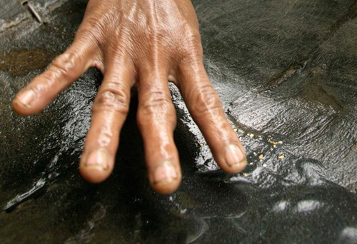A villager looks for gold dust from sand along a river at Pidie district, Indonesia’s Aceh province 