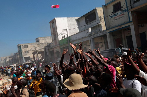 Looters fight for products at a business area in Port-au-Prince January 16, 2010. Four days after a massive quake killed up to 200,000 people and wrecked most of the capital Port-au-Prince, hundreds of thousands of Haitians were still desperately waiting for assistance as scavengers and looters preyed on shattered buildings in the widespread absence of authority and order.