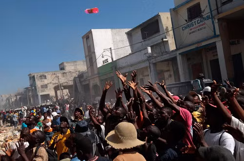 Giơ tay nhận đồ ném ra từ một cửa hàng ở thủ đô Port-au-Prince Looters fight for products at a business area in Port-au-Prince January 16, 2010. Four days after a massive quake killed up to 200,000 people and wrecked most of the capital Port-au-Prince, hundreds of thousands of Haitians were still desperately waiting for assistance as scavengers and looters preyed on shattered buildings in the widespread absence of authority and order.