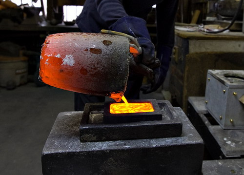 Robert Stoler pours molten gold into an ingot mold at Dvir & Stoler Refining in New York, U.S